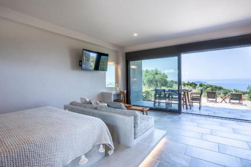 a bedroom with a bed and a view of a patio at Alterra Vita Eco Villas in Neos Marmaras