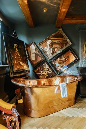 a copper tub filled with pictures on a wall at Boutique Hotel The Noblemen in Amsterdam
