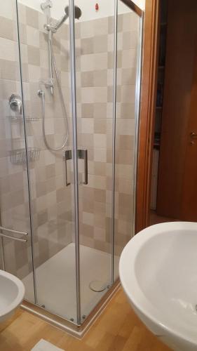 uma casa de banho com uma cabina de duche em vidro e um lavatório. em La casa del Capitano em Scerne