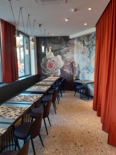 uma fila de mesas e cadeiras num quarto com cortinas vermelhas em Hôtel Prince Albert Concordia em Paris