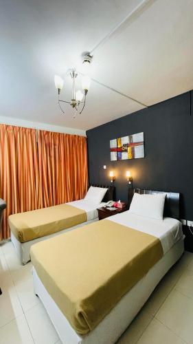 a hotel room with two beds and an orange curtain at Royal Prince Hotel in Dubai