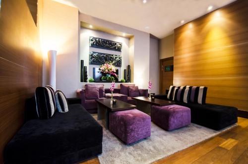 a waiting room with purple chairs and tables at Hotel NH Poznan in Poznań