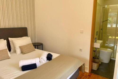 een slaapkamer met een bed met handdoeken erop bij Santo António Cozy Apartment in Porto