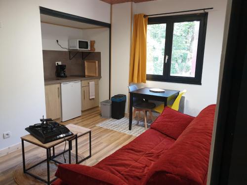un salon avec un canapé rouge et une table dans l'établissement L'Atelier du Rêve, à Brides-les-Bains