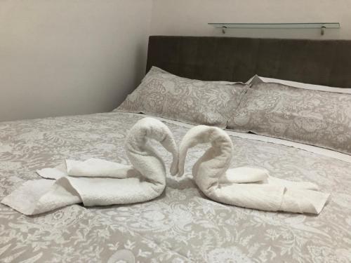 2 cygnes de serviettes assises au-dessus d'un lit dans l'établissement Casa Morganti-, à Sesto San Giovanni