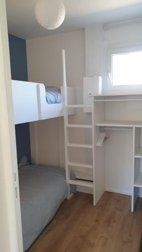 a bedroom with two bunk beds and a desk at COSY T3 LACANAU in Lacanau