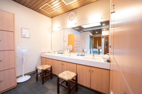 a bathroom with a sink and a large mirror at Hotel Ark 21 in Kurayoshi