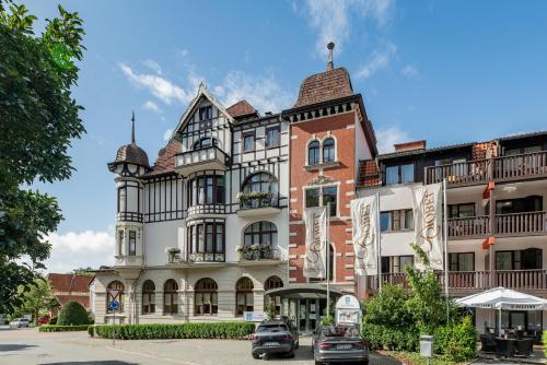 a building with cars parked in front of it at Göbel´s Vital Hotel Bad Sachsa in Bad Sachsa