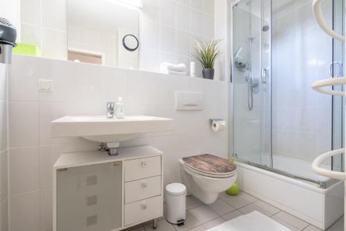 ein Bad mit einem Waschbecken, einem WC und einer Dusche in der Unterkunft Feriendorf Rugana - Komfort Appartement mit 1 Schlafzimmern und Terrasse C39 in Dranske
