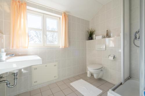 uma casa de banho branca com um WC e um lavatório em Feriendorf Rugana - Budget Appartement mit 1 Schlafzimmer C40 em Dranske
