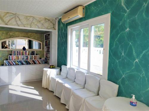a living room with white chairs and a green wall at Sun Shine Senior Suite Full View in Hersonissos