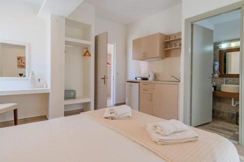 1 dormitorio blanco con 2 toallas en una cama en Christina Boutique Studios Elounda, en Elounda