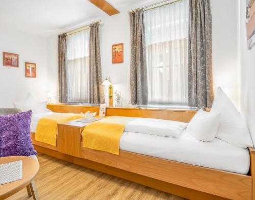 two beds in a room with two windows at Wander und Aktiv Hotel Rösslwirt in Lam