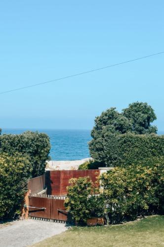 a house with trees and the ocean in the background at Casa da Bonança Ofir in Fão