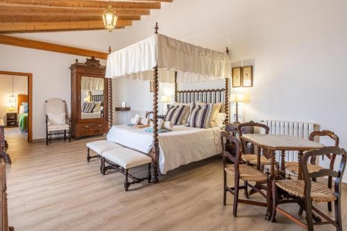 a bedroom with a canopy bed and a table and chairs at Son Veri Dalt in Llucmajor
