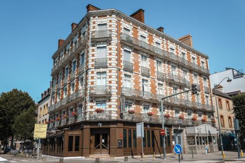 un grand bâtiment avec balcon dans une rue de la ville dans l'établissement Hotel De La TA, à Rennes