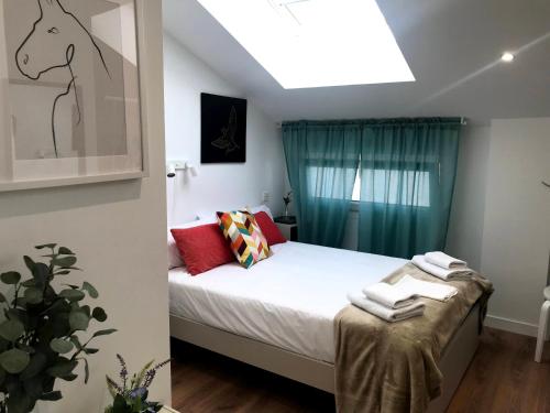Un dormitorio con una cama y una ventana con toallas. en INSIDEHOME Apartments - La Casita de Úrsula, en Palencia