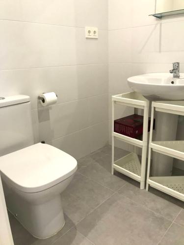y baño con aseo y lavamanos. en INSIDEHOME Apartments - La Casita de Úrsula, en Palencia