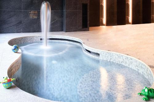 a swimming pool with a water fountain in a building at SPA VILNIUS Druskininkai in Druskininkai
