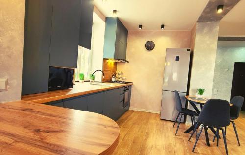 a kitchen with a wooden table and a refrigerator at Нові Ексклюзивні Апартаменти біля Софіївського Парку in Umanʼ