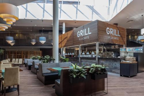 a restaurant with tables and chairs and a grill at Holiday Club Vierumäki in Vierumäki