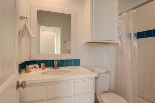 ein Badezimmer mit Waschbecken, Toilette und Spiegel in der Unterkunft Harpers Berry 5SC in Port Aransas