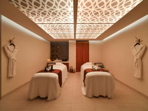 a spa room with four beds in a room at Alwadi Hotel Doha - MGallery in Doha
