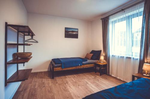 a bedroom with a bed and a large window at Apartmány pod Suchým vrchem in Stachy