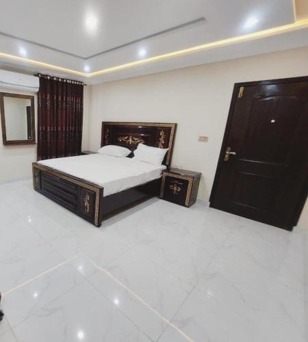 a bedroom with a bed and a black door at Hotel White Pearl in Lahore