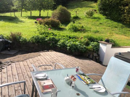 a glass table and chairs on a patio at Foresters Lodge bed and breakfast, near loch ness in Inverfarigaig