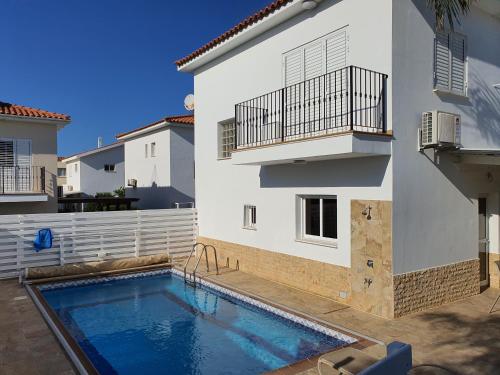 a house with a swimming pool next to a building at Protaras sea view Villa with private pool in Protaras