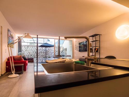 eine Küche mit einem Waschbecken und ein Wohnzimmer in der Unterkunft Sweet Piccolo Loft in centro con incantevole idromassaggio in Meran