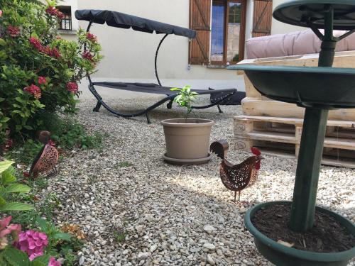 two chickens standing in a garden with a bird bath at L auberge du lion d or in Nanteuil-sur-Marne