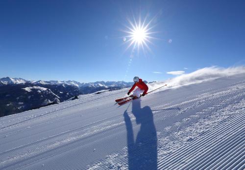 a person is skiing down a snow covered slope at Naturhotel Hüttenwirt im Grossarltal in Hüttschlag