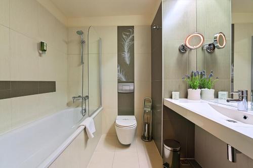 ein Bad mit einem WC, einem Waschbecken und einer Dusche in der Unterkunft Hotel Cubix in Braşov