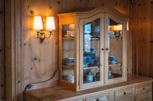 a wooden cabinet with china in a room at Chalet Crown of the Alps by we rent in Zell am See