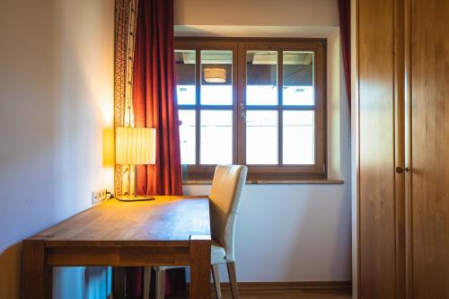 a dining room table with a lamp and a window at Chalet Crown of the Alps by we rent in Zell am See