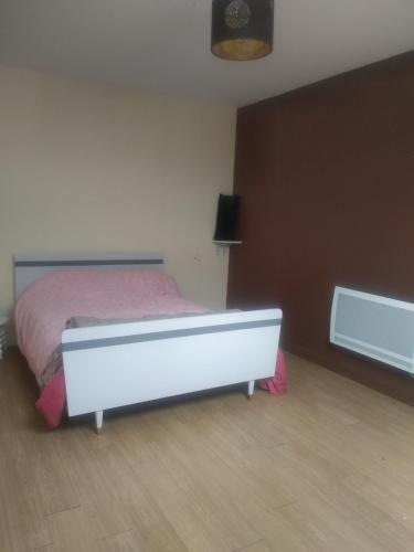 a bedroom with a bed with a pink bedspread at Maison de campagne à la ferme in Pillac
