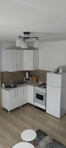 a kitchen with white cabinets and a sink and a stove at Vikend house in Ljig