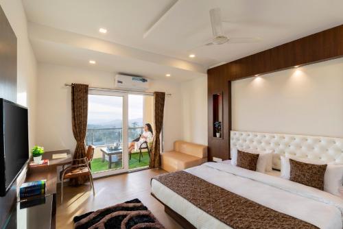 a hotel room with a bed and a balcony at Blizzard Resort in Panchgani
