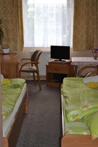 a room with two beds and a desk with a computer at Zajazd Maxim in Żywiec