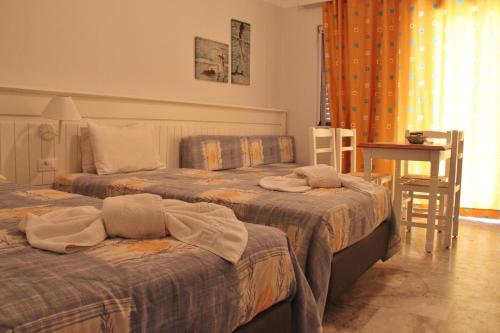 a hotel room with two beds and a table at Santa Irene in Sougia