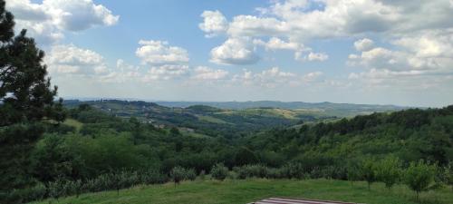 a view of a valley from a hill with trees at Vikend house in Ljig