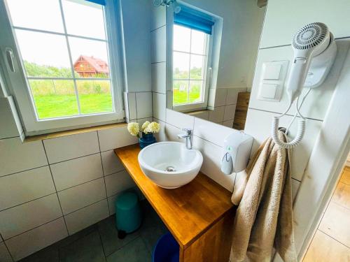 ein Bad mit einem Waschbecken und einem Spiegel in der Unterkunft Domki Summer Home Łeba in Łeba