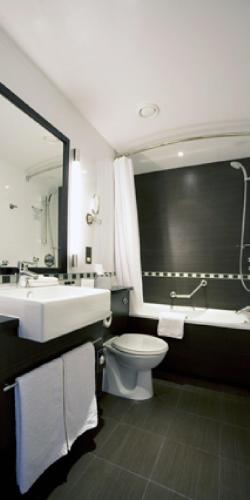 a bathroom with a sink and a toilet and a tub at Crowne Plaza London - Gatwick Airport by IHG in Crawley