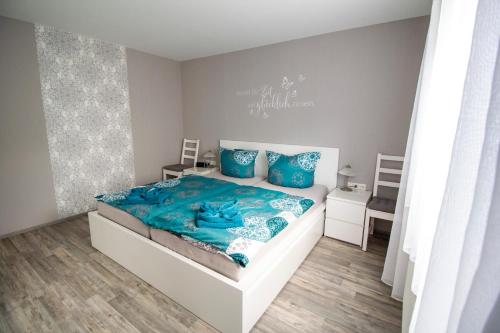 een slaapkamer met een bed met blauwe lakens en blauwe kussens bij Ferienwohnung Eifelurlaub in Daun