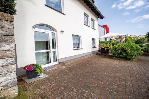a white house with a brick patio at Ferienwohnung Eifelurlaub in Daun