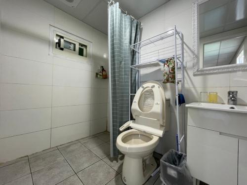 a bathroom with a toilet and a sink at 31 Backpack Guest House in Renai