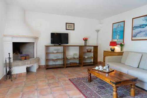 a living room with a couch and a tv at Frascati Country House in Grottaferrata