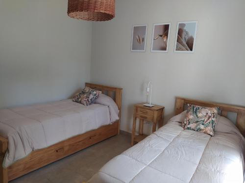 a bedroom with two beds and a table with a lamp at Pinamar Norte Casa Aquiles 8 pax in Pinamar